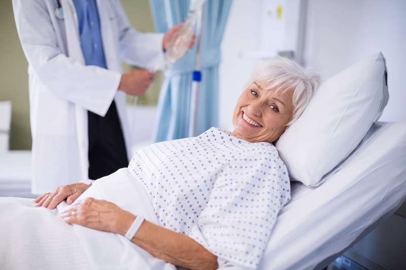 Ältere Dame liegt im Krankenhaus und ist glücklich